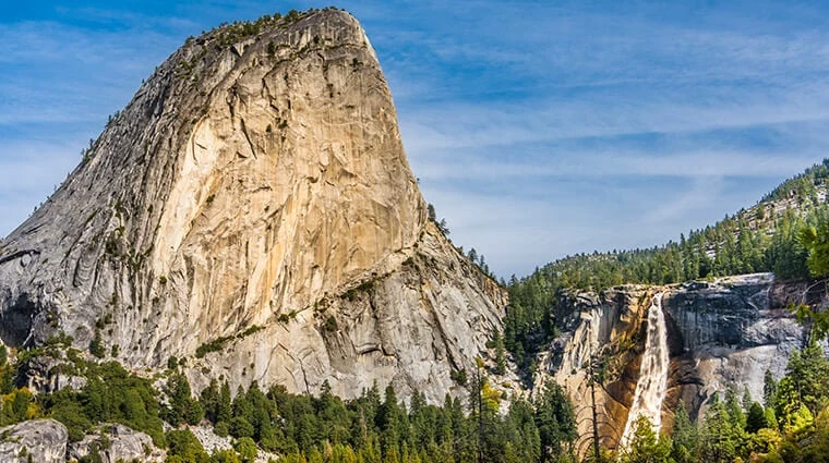Nevada Fall cascading beside the granite dome of Liberty Cap